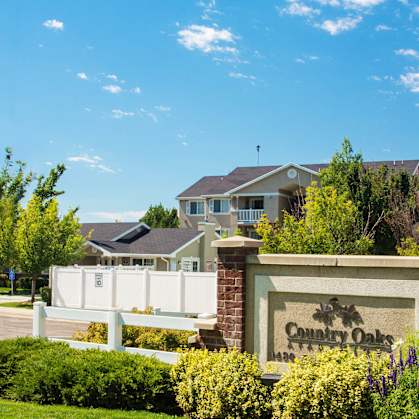 a subdivision sign in front of a house  at Country Oaks Apartments in Clearfield, Utah