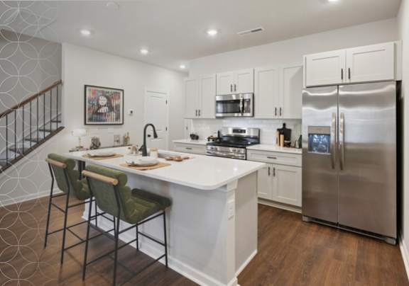 A kitchen with a refrigerator, sink, and stove.