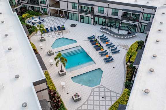 an aerial view of a pool and patio area of a hotel