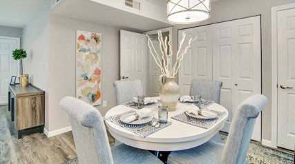 A dining room with a round table set for four.