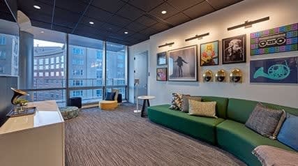 a large room with a green couch and many pictures on the wall