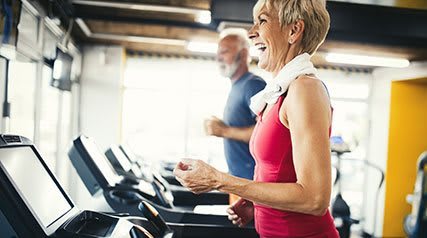 Elderly man and woman on treadmills