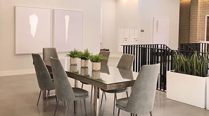 a dining room with a glass table with chairs and potted plants at The Georgian Apartments, St Louis, 63104