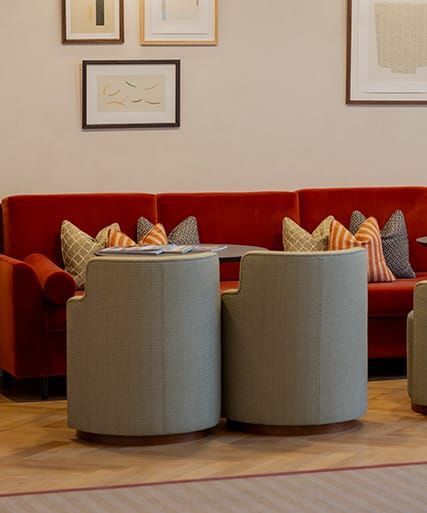 a lobby with a staircase and a table and chairs