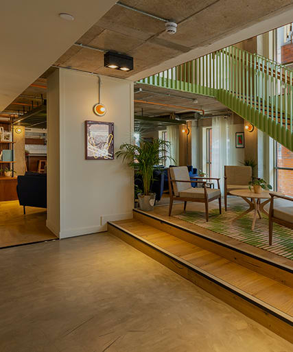 a lobby with a staircase and a table and chairs