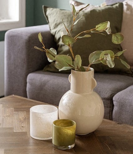 a living room with a gray couch and a glass coffee table