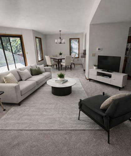 A modern living room with a grey carpet and white furniture.