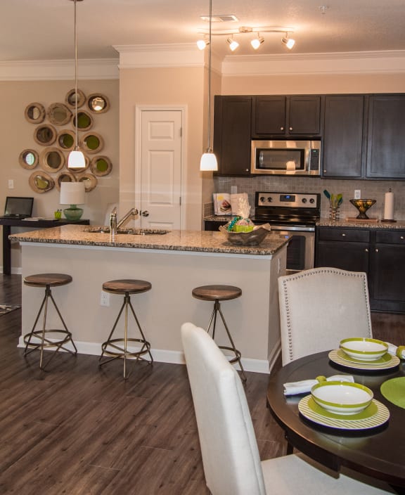 a kitchen and dining room area with a table and chairs and a counter at Echo at Lake Norman, Mooresville, NC