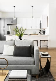 a living room with a couch and a kitchen in the background
