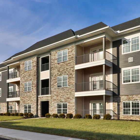 an exterior view of an apartment building on a sunny day