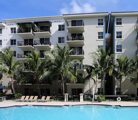 a large swimming pool in front of an apartment building