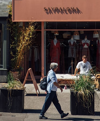 people standing on a sidewalk in front of a building