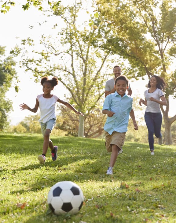 a group of people playing soccer in a park at Magnolia Pointe Apartments in Duluth, GA
