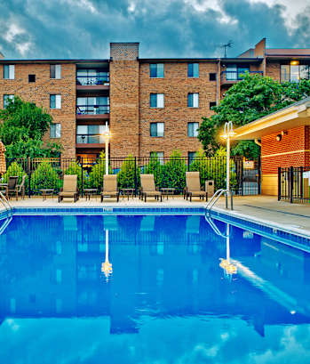 A large swimming pool in front of a brick building.