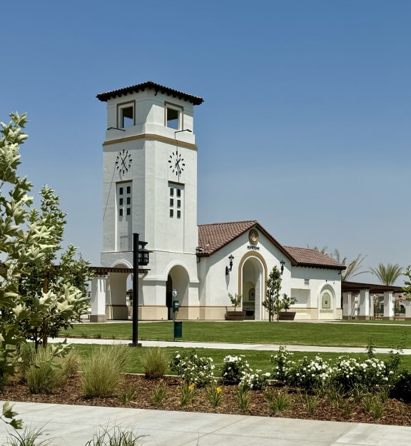 a church with a clock tower in the middle of a sidewalk