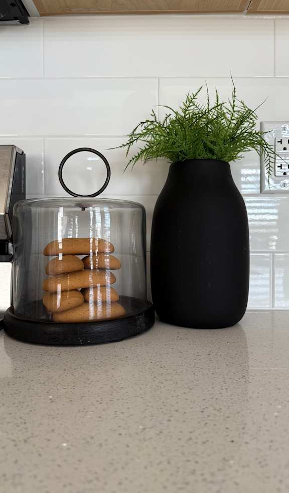 black wooden cake stand with a glass cloche lid. at The Pointe at Riverview, Edmonton