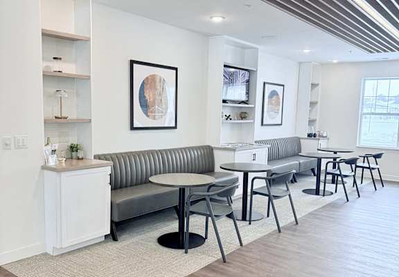 A modern living room with a grey sofa and a white sideboard.