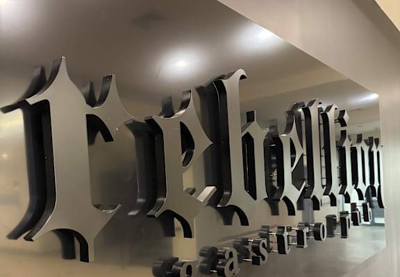 A wall of black letters spelling out the word "Jeddah" in a row.