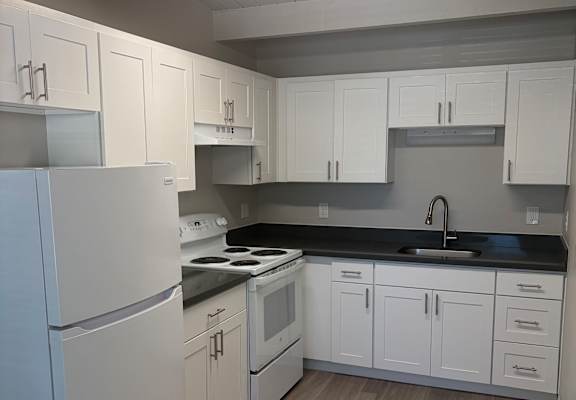 A modern kitchen with white appliances and cabinets.