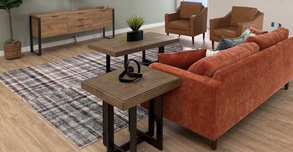 A living room with a red couch, a wooden coffee table, and a wooden bench.