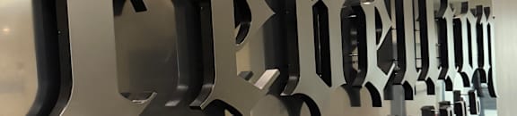 A wall of black letters spelling out the word "Jeddah" in a row.