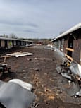 A train track with a train car that has derailed and is on the side of the track.