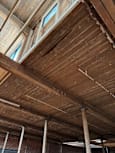 A wooden ceiling with beams and a skylight.