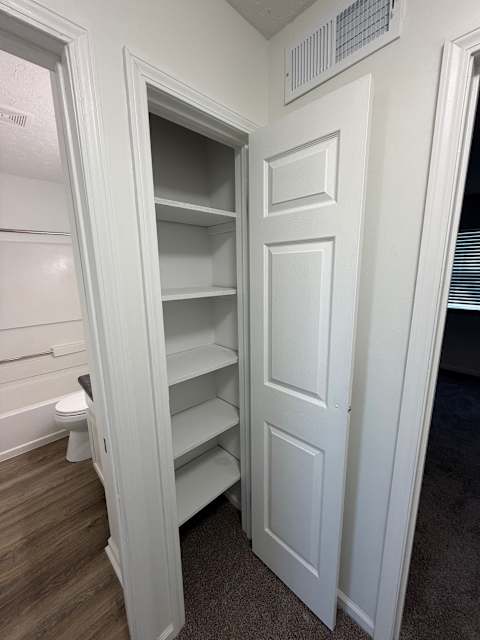 A white door with shelves on the inside is open.