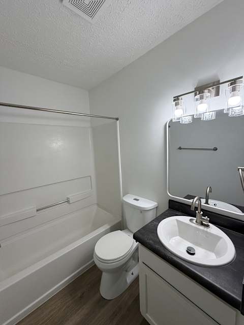 A white toilet sits next to a sink in a small bathroom.