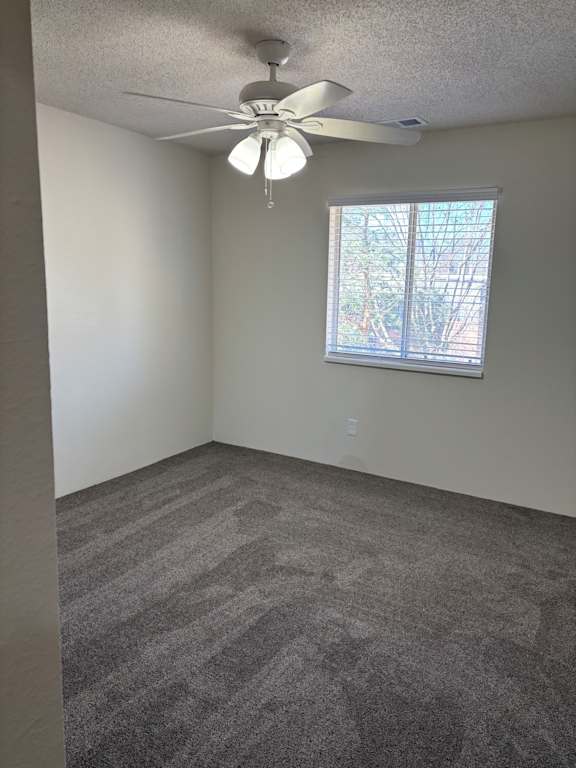 A bedroom with a ceiling fan and a window at Muirfield Apartments.