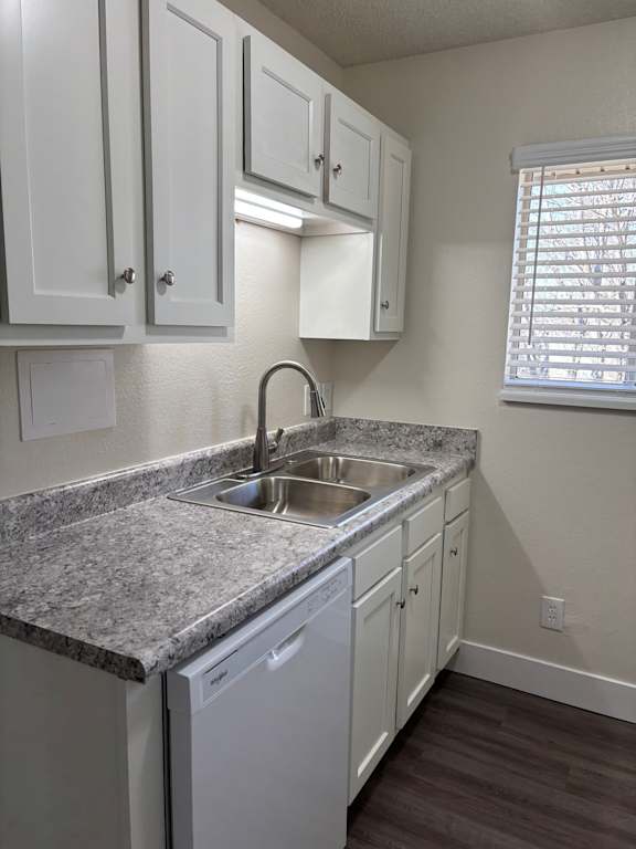 Remodeled kitchen with updated cabinets, white appliances, and clean finishes at Muirfield Apartments.