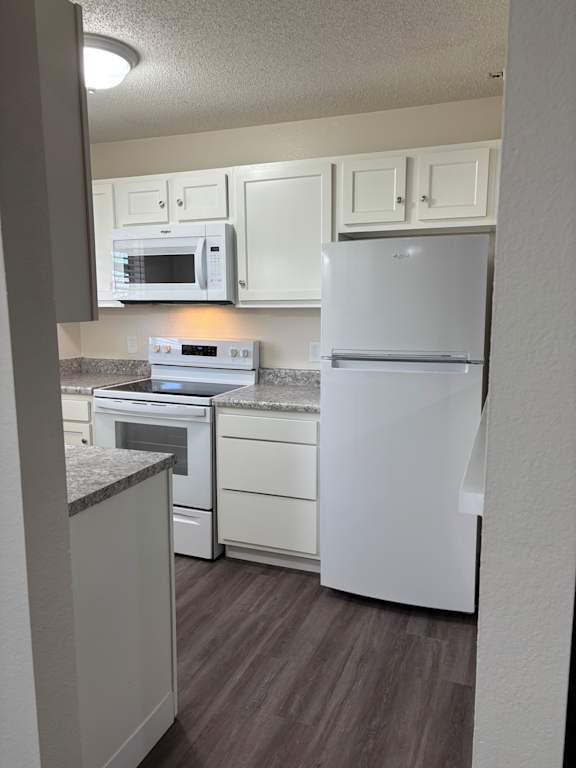 Remodeled kitchen with updated cabinets, white appliances, and clean finishes at Muirfield Apartments.