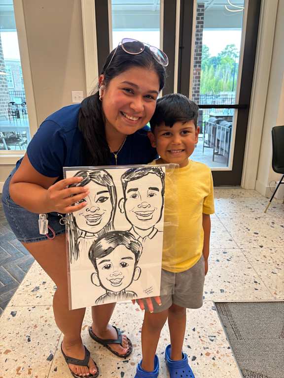 A woman is holding a drawing of three people.