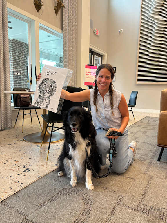 A woman is sitting on the floor with a dog.