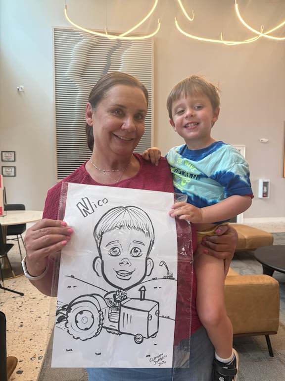 A woman holding a drawing of a boy with a robot.