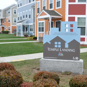 a sign for temple landing in front of a row of houses