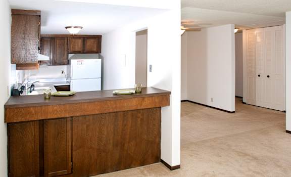 A kitchen with brown cabinets and a white refrigerator.