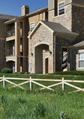 an apartment building with a white fence in front of it