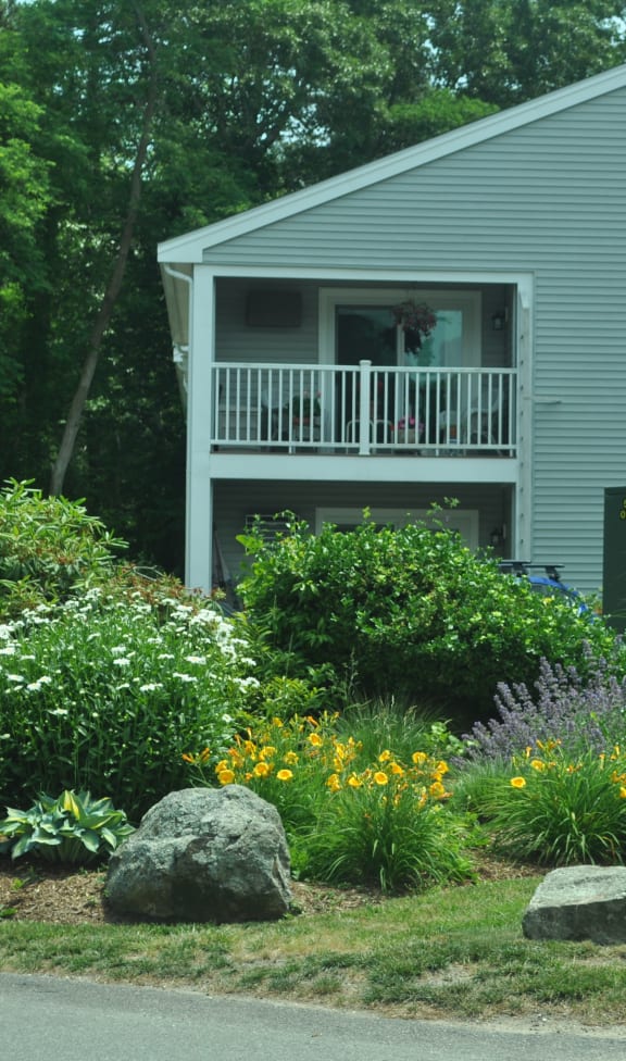 a garden in front of a house with a porch