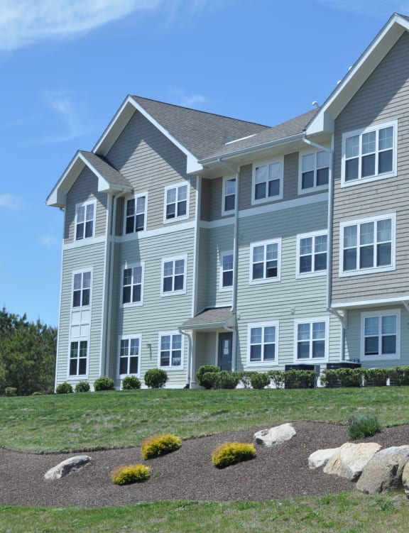 a large apartment building with large rocks in front of it