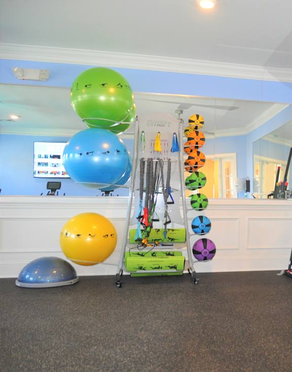 A room with a white reception desk and exercise equipment.