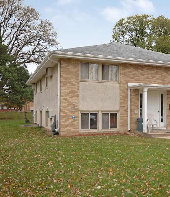 A brick house with a white door and windows.