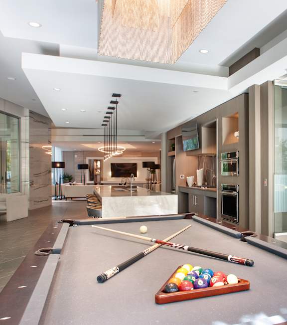 A pool table in a room with a glass wall.