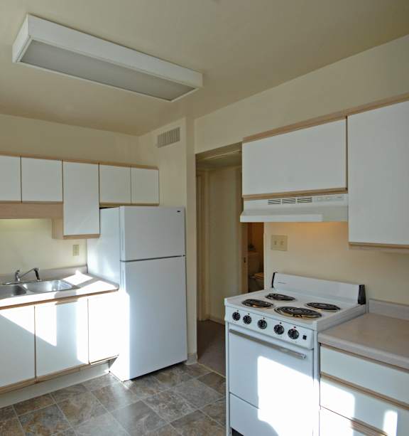 A kitchen with white appliances and cabinets.
