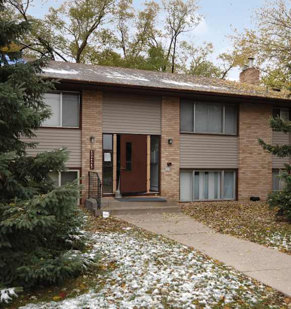 A house with a brown door and a brown roof.