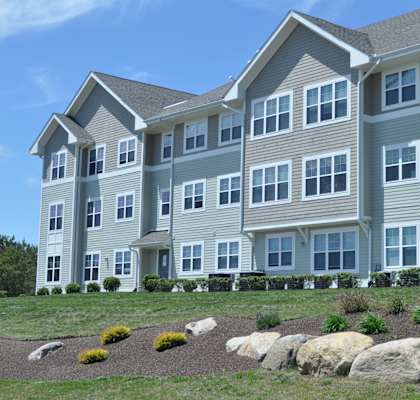 a large apartment building with large rocks in front of it