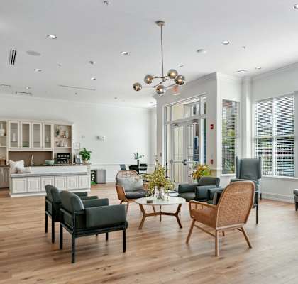 A modern living room with a kitchen in the background.