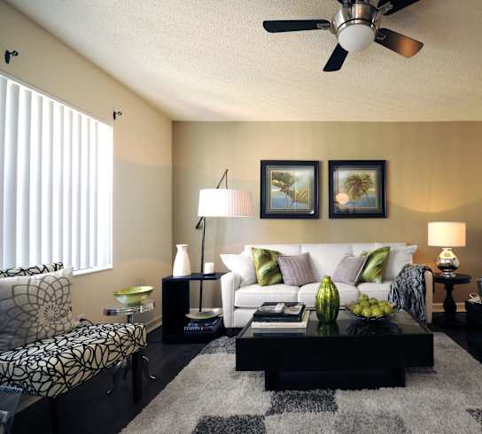 a living room with a couch and a coffee table and a ceiling fan