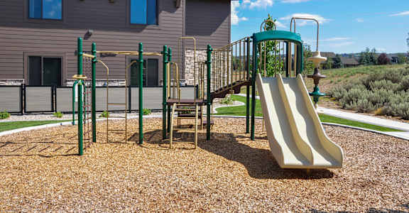 A playground with a slide, swings, and a climbing frame.