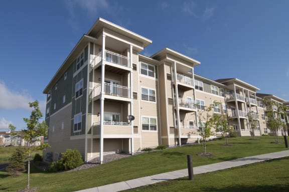 a large apartment building with balconies and a sidewalk
